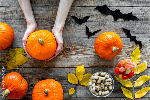 Halloween background. Pumpkins, paper bats and autumn leaves on wooden background top view photo