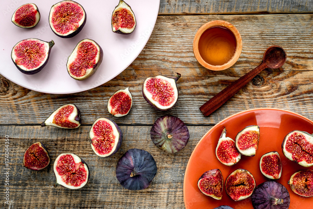 Plate of fresh blue figs on wooden background top view