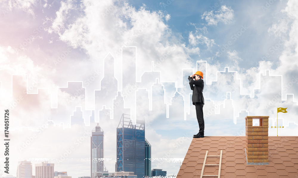 Engineer man standing on roof and looking in binoculars. Mixed media Engineer man standing on roof and looking in binoculars. Mixed media