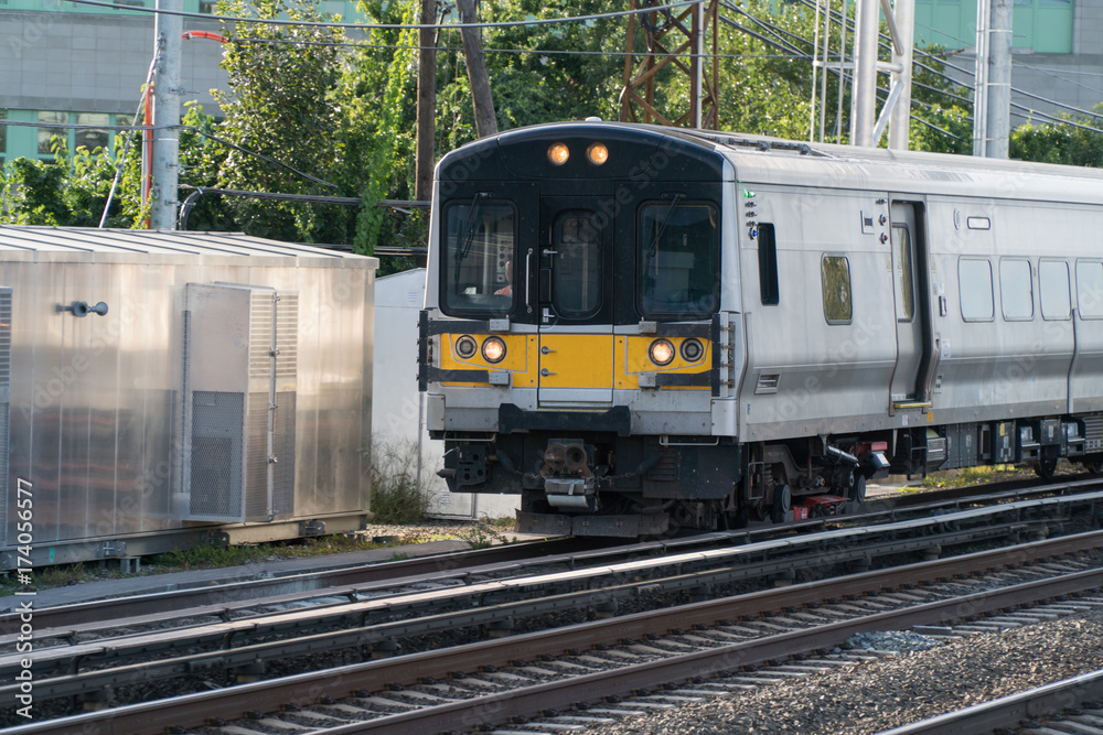 Generic electric power passenger commuter train on tracks carry people home and work for rush hour. Day time outside photo