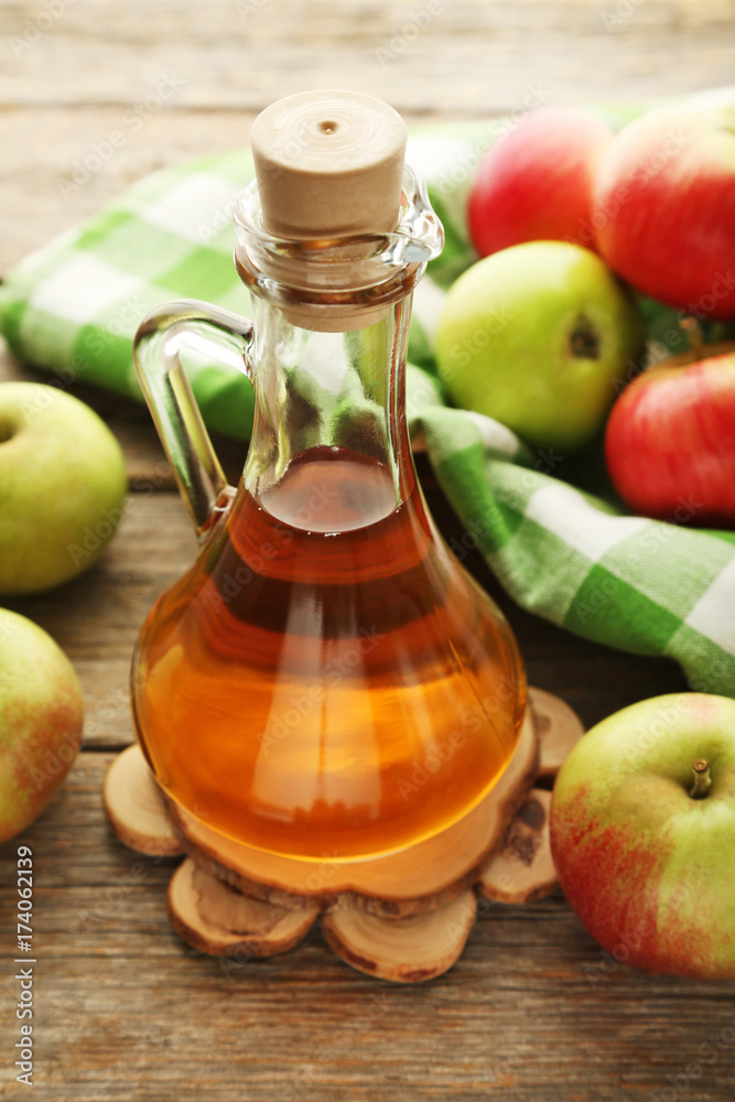 Apple vinegar in glass bottle on grey wooden table