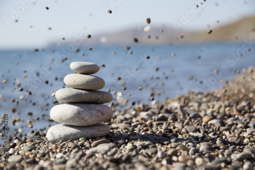 Photography Against the background of the sea a pyramid of stones