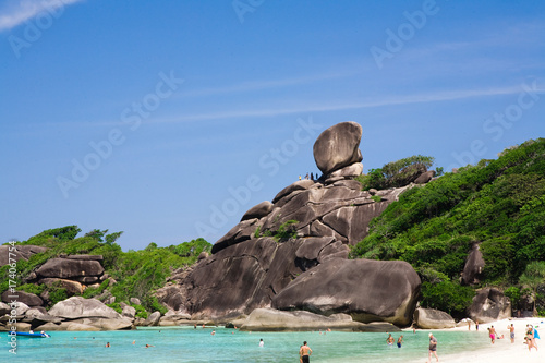 Island with Sailing Boat Rock in Similan National park, Phang Nga, Thailand. Tourists arrive by boat and to walk through the waves to the beach photo