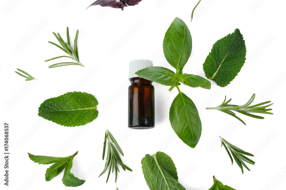Bottle with oil and leaves of different herbs on white background Bottle with oil and leaves of different herbs on white background