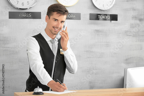 Male receptionist working i...