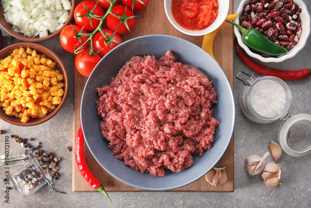 Raw minced meat and vegetables on kitchen table Raw minced meat and vegetables on kitchen table