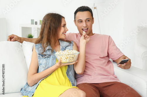 Young couple watching TV at...