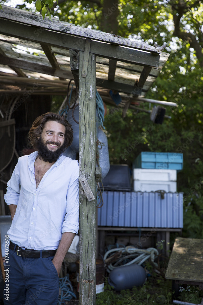 Young man hanging out under a shed