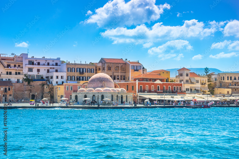 View of the old harbor of Chania with horse carriages and mosque, Crete, Greece.