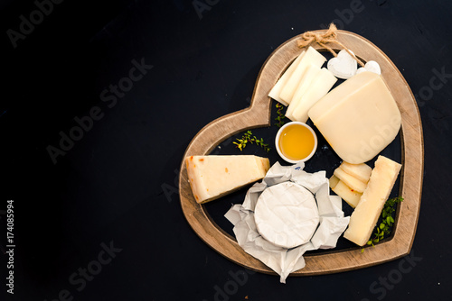 various types of cheese on a stand in the shape of a heart, concept elegant life and love cheese, top view
