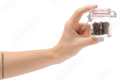 Female hand holding a jar with spice barberry