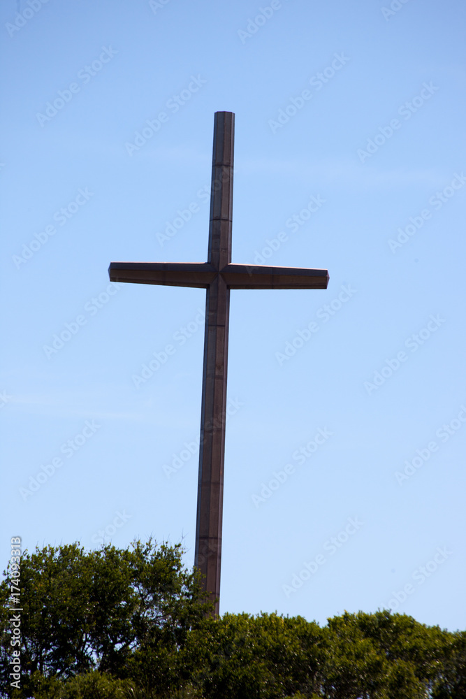 Large metal cross above the trees Large metal cross above the trees