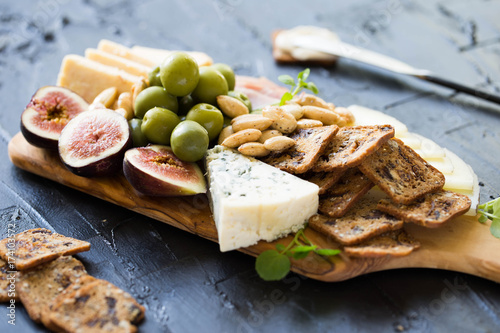 Beautiful Date Night Cheese Board with Cheddar Manchego and Blue Cheese Prosciutto Almonds and Olives on Wooden