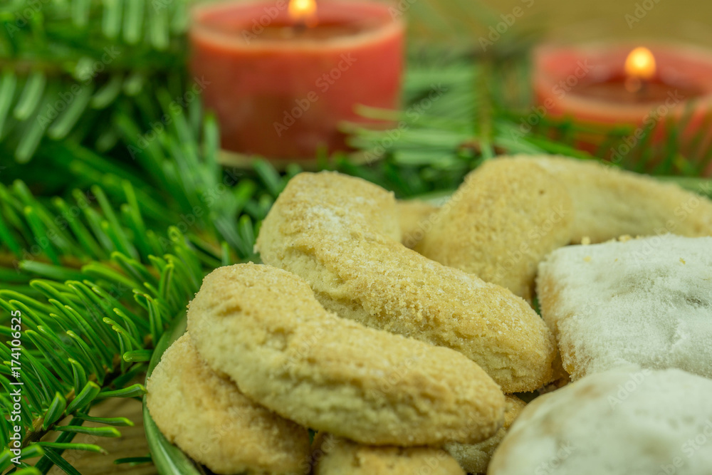 Christmas decoration - pine branch with red candles and Christmas biscuits Christmas decoration - pine branch with red candles and Christmas biscuits