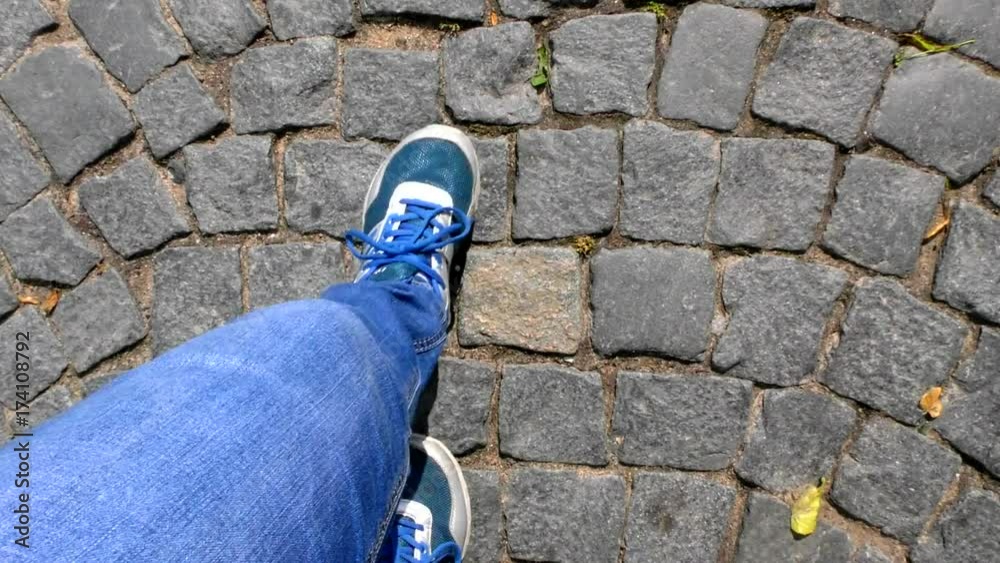 The legs are on the pavement. Walk through the old district of the ancient city in the fall. Walking on the pavement - a selfie.