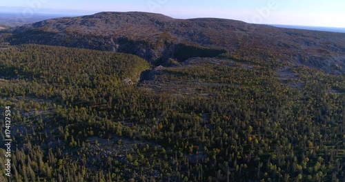 Tunturi mountain, Cinema 4k aerial decreasing tilt view of a canyon, forrest and noitatunturi fjeld, in lapland pyha-luosto national park, on a sunny autumn day, in Lappi, Finland photo