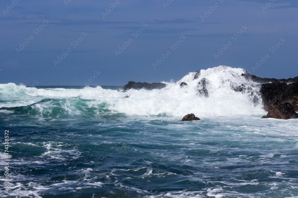 Waves crash onto volcanic rocks.  The Pacific Ocean at Playa San Juanillo, Costa Rica.