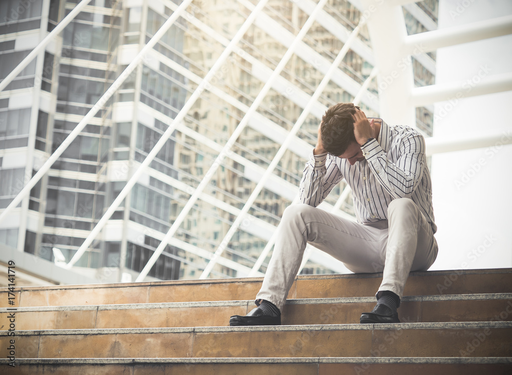 Upset young caucasian businessman tired from work sitting at stairs, unemployment, fired from job, disappointed, loss and feeling down concept Upset young caucasian businessman tired from work sitting at stairs, unemployment, fired from job, disappointed, loss and feeling down concept