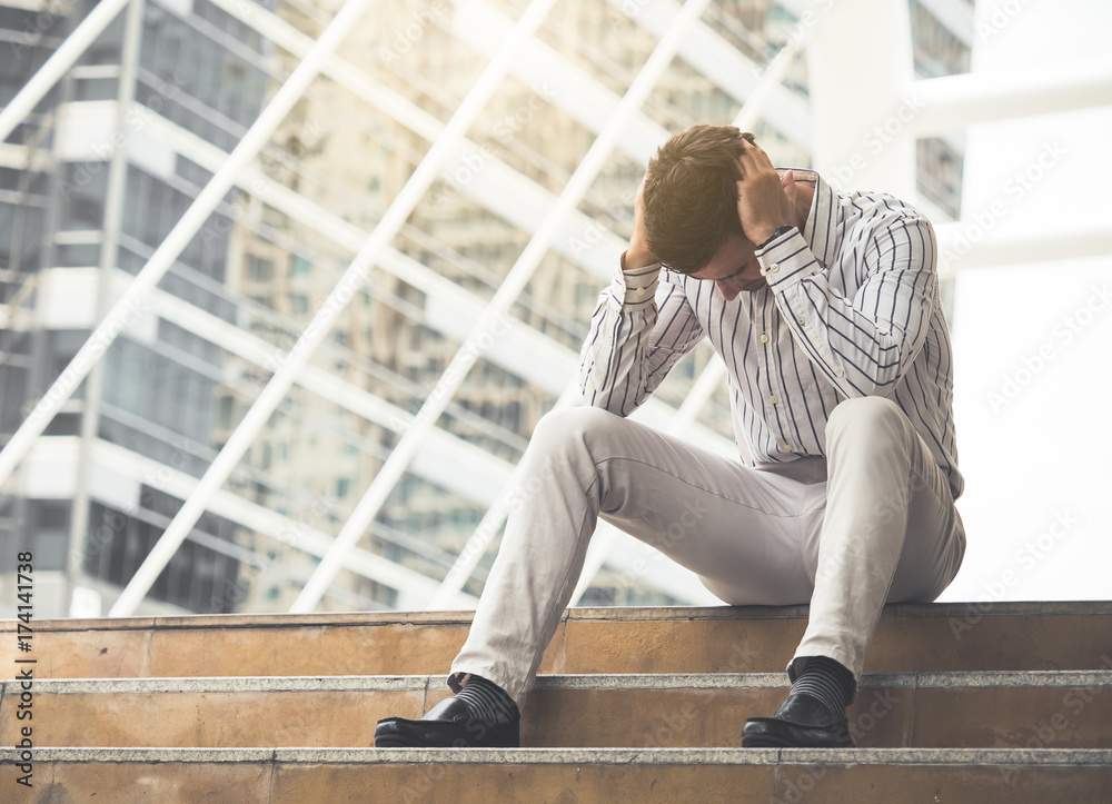Upset young caucasian businessman tired from work sitting at stairs, unemployment, fired from job, disappointed, loss and feeling down concept
