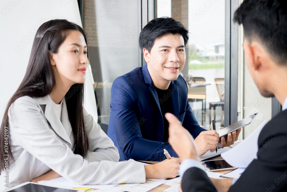Young asian businessman and Businesswoman discussing in the meeting in office cafe, brain storming for business strategy with happy feeling and smile Young asian businessman and Businesswoman discussing in the meeting in office cafe, brain storming for business strategy with happy feeling and smile