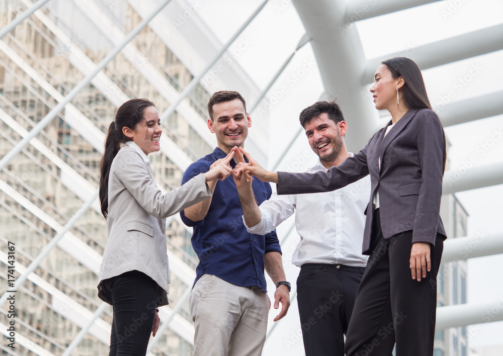 young businessman and businesswoman express teamwork, stacking hands at outdoor office young businessman and businesswoman express teamwork, stacking hands at outdoor office