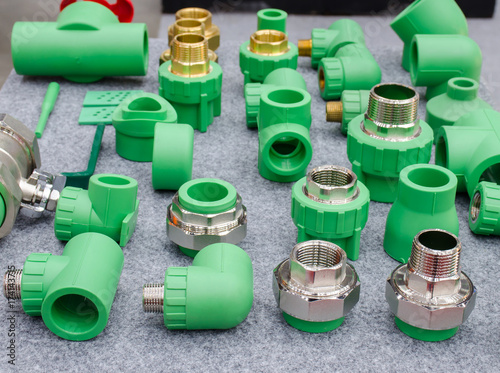 PPR water pipe fittings,Plumbing connection fittings for plastic pipes. Orderly arranged in neat rows. Abstract industrial background.