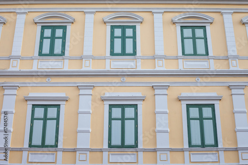Green Windows on Yellow Vintage wall Pattern and wallpaper has architecture in Bangkok Thailand.