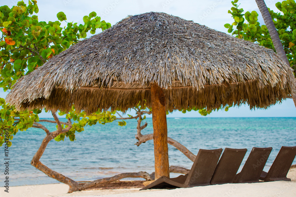 Fototapeta premium Sun umbrella and beach beds on tropical coastline, Philippines, Boracay