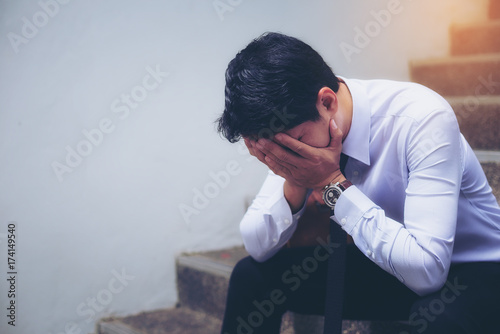 Portrait of a handsome young businessman who is sitting sadly disappointed by the business.