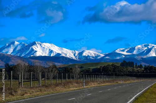 Rural road of New Zealand with covered snow mountain