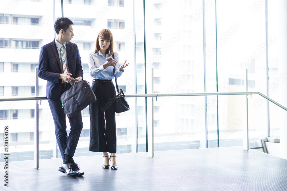 Business couple are eagerly conversing at the window
