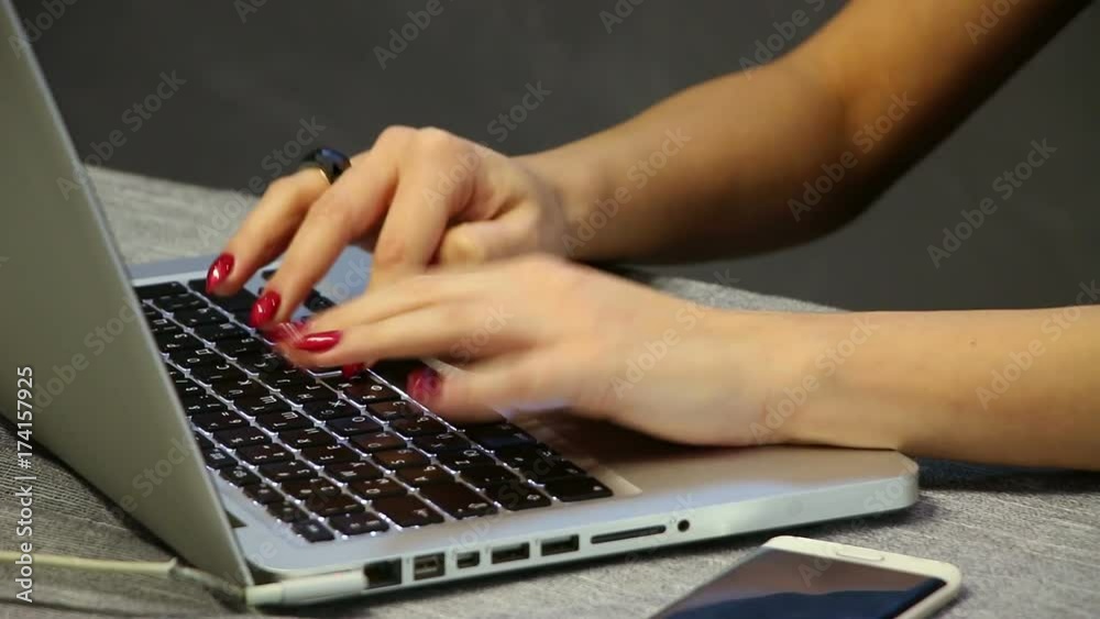 Businesswoman working on notebook laptop computer in the office. Detail shot of attractive woman fingers with red nice manicure. Businesswoman working on notebook laptop computer in the office. Detail shot of attractive woman fingers with red nice manicure.