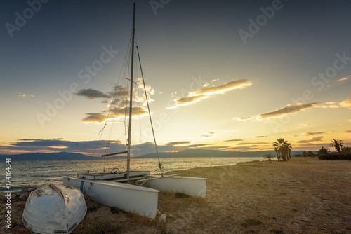 Sailboat on the beach at sunset