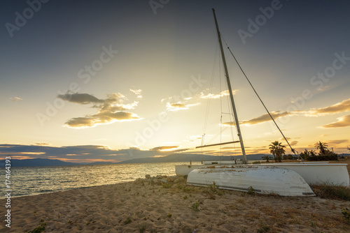 Sailboat on the beach at sunset