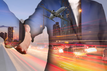 Double exposure of businessman handshake, airplane flying, light trails on street, city and urban in the night as business, commitment, welcome, congratulation, transportation and travel concept