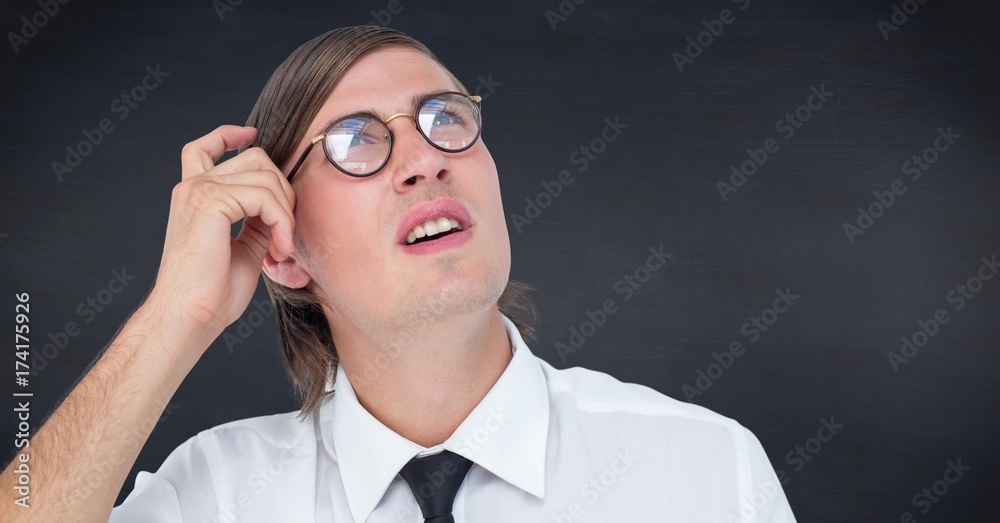 Close up of nerd man scratching head against navy chalkboard Close up of nerd man scratching head against navy chalkboard