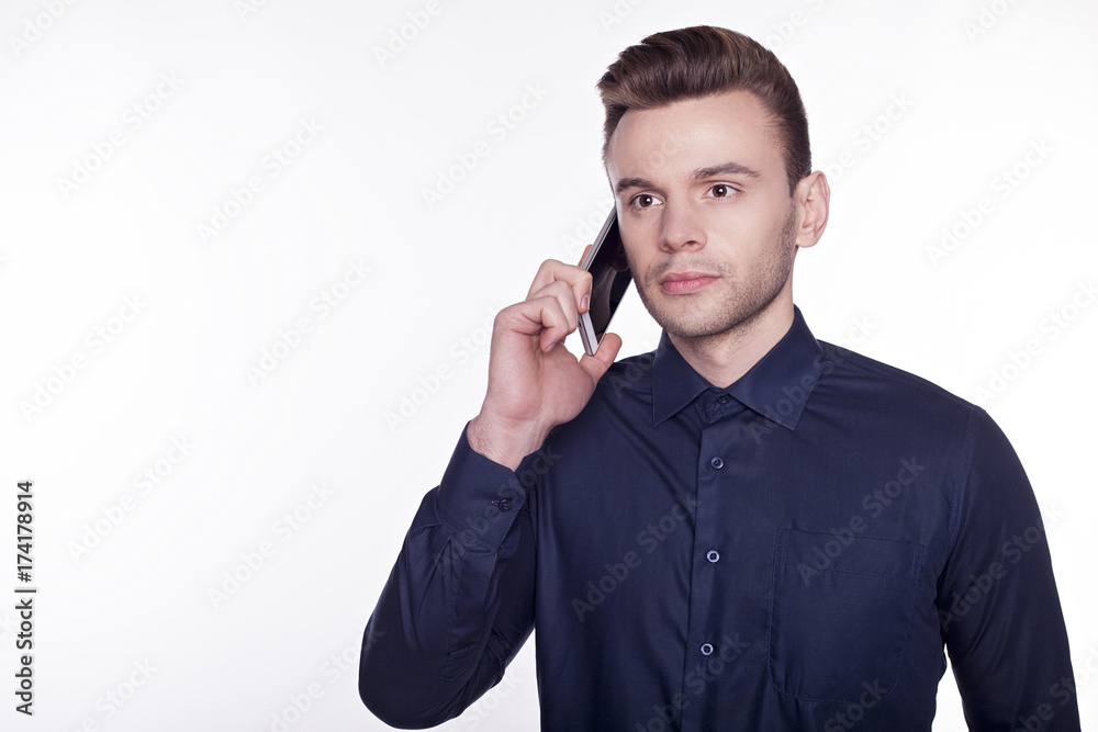 A portrair of a confident business man isolated on white background talking on his phone. A portrair of a confident business man isolated on white background talking on his phone.