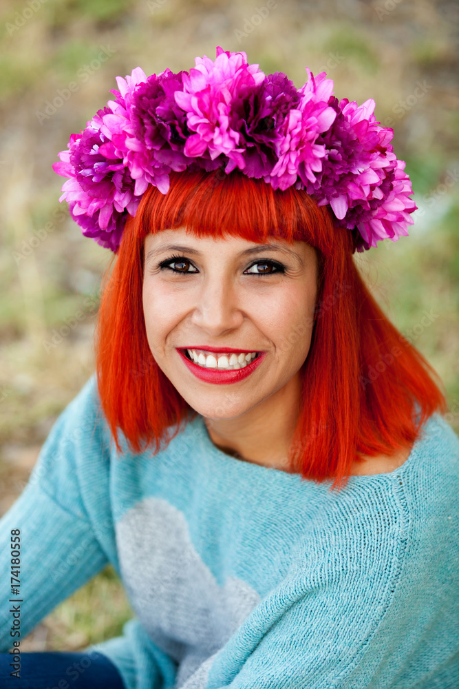 Attractive red haired girl with wreath of flowers
