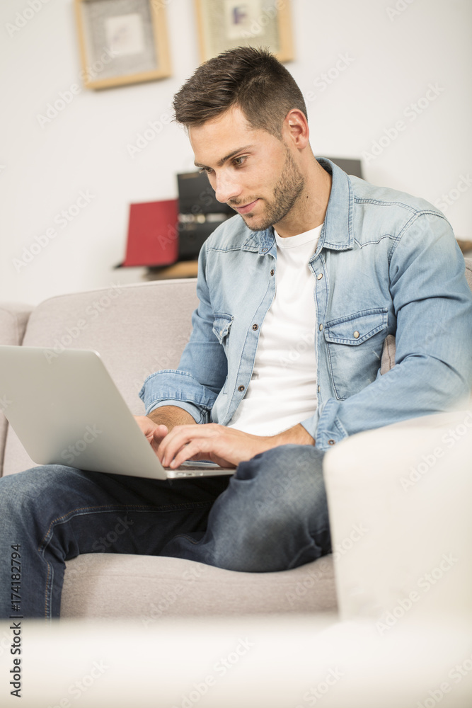 Upper view of young man using laptop computer at home Upper view of young man using laptop computer at home