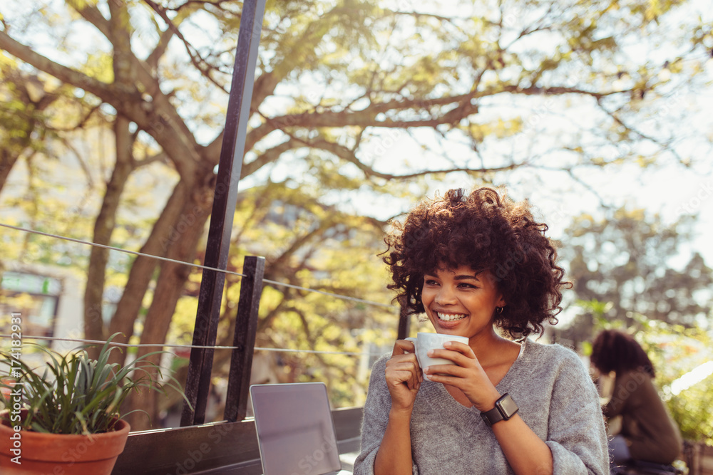 Fototapeta premium Young woman drinking coffee outdoors