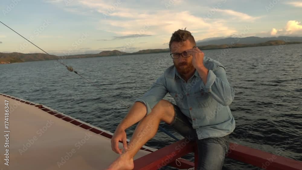Man relaxing on the boat and smiling to the camera, slow motion shot at 240fps, steadycam shot
Man relaxing on the boat and smiling to the camera, slow motion shot at 240fps, steadycam shot