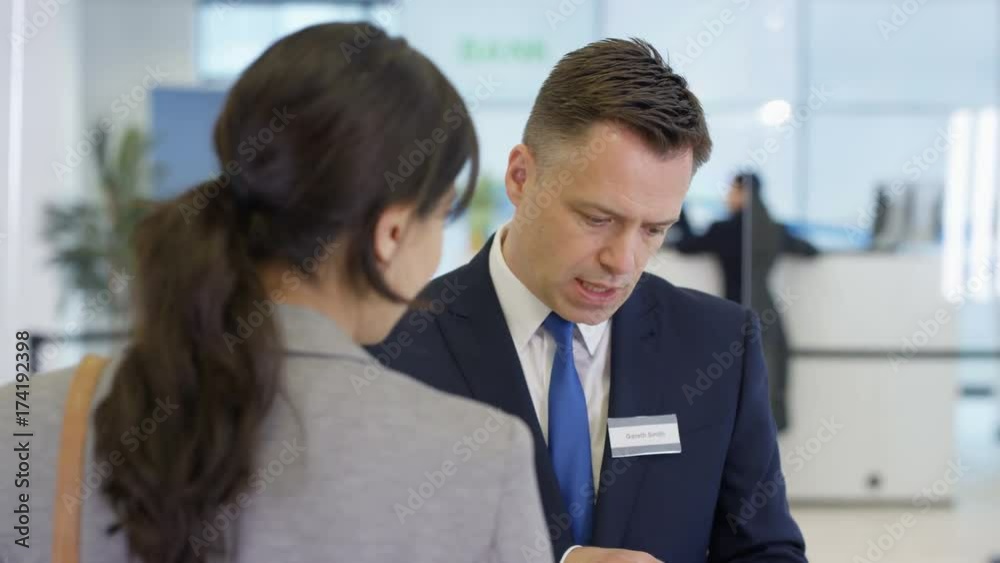Friendly bank workers talking to customers & offering financial advice Friendly bank workers talking to customers & offering financial advice