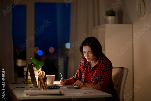 student girl with notebook and calculator at home