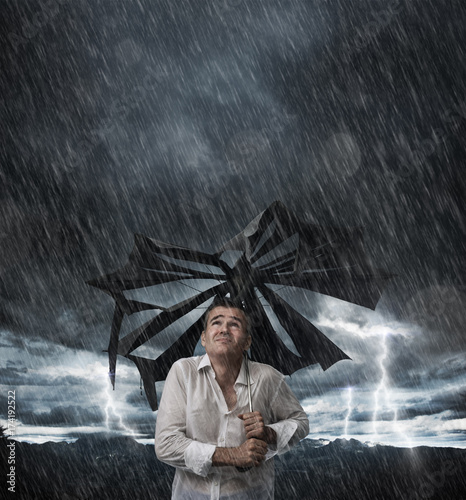 Fotografie Wet man with broken umbrella
