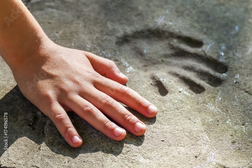 Childs hand and memorable handprint in concrete