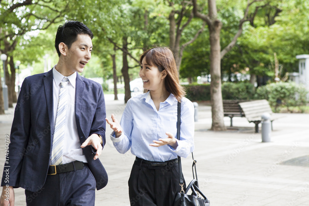 Business couple talking while walking in the park Business couple talking while walking in the park