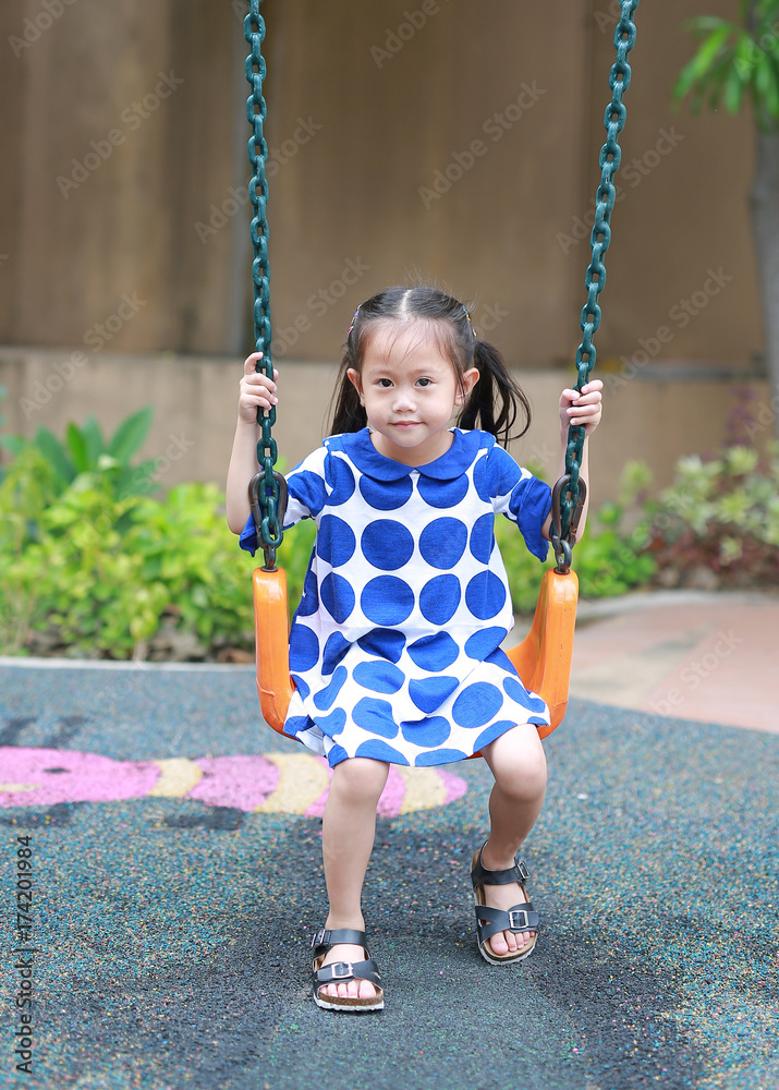 Asian little enjoy playing swing in the playground. Asian little enjoy playing swing in the playground.