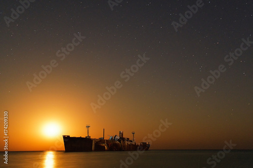 The wrecked ship under starry night with moonrise. long expose