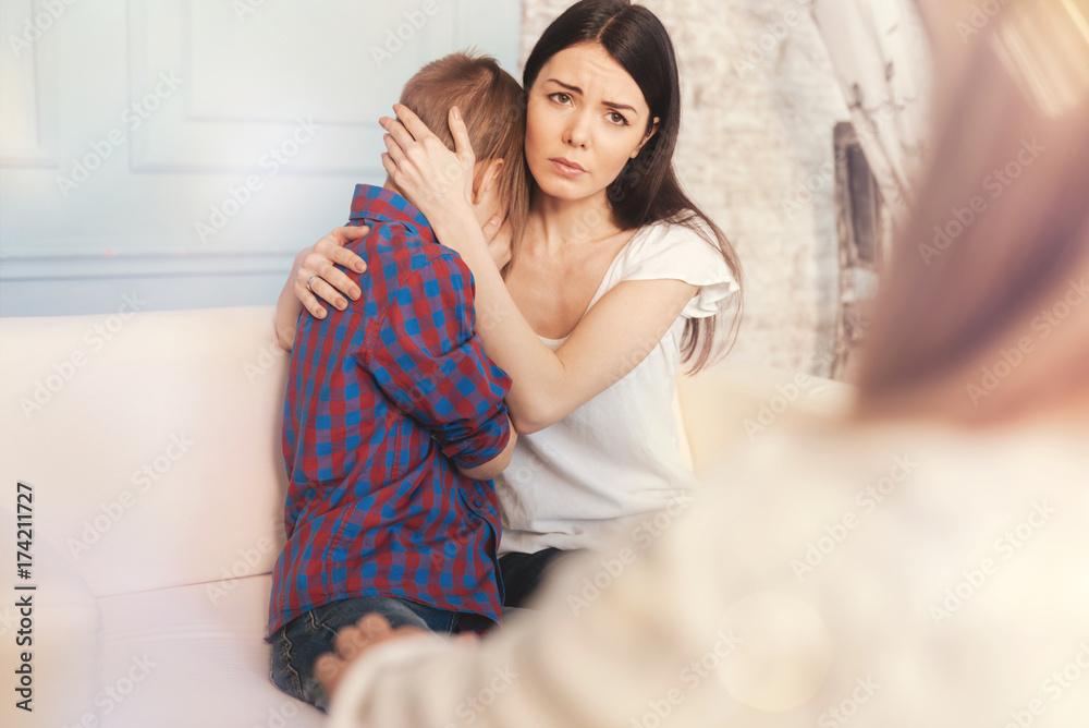 Troubled mother and her son talking with a psychologist Troubled mother and her son talking with a psychologist