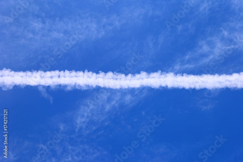 Trail of airplane in the blue sky. © Vitalii